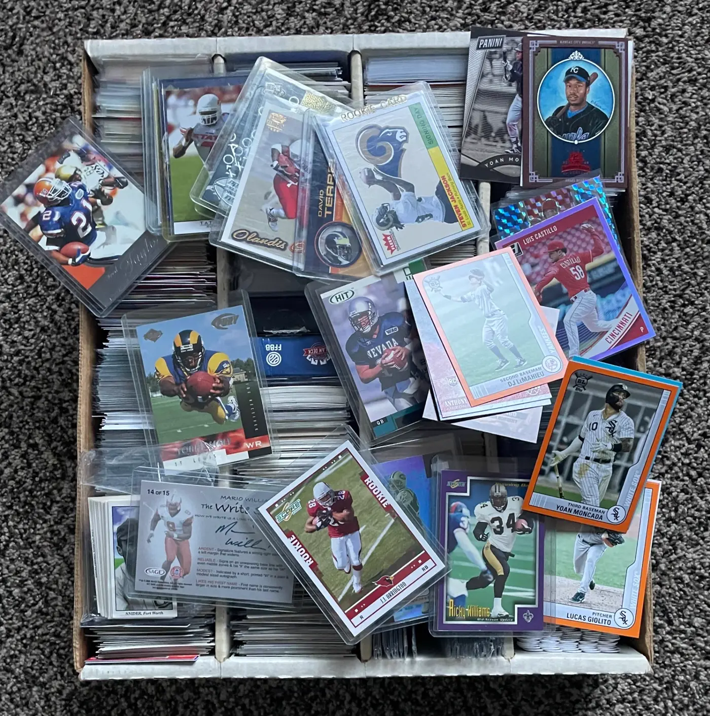 Box of football and baseball rookie cards in sleeves from a collection we purchased