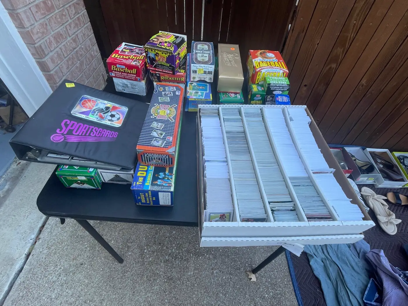 Sports card collection laid out for evaluation - baseball wax boxes, complete sets and a monster box of cards
